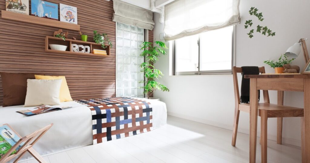 木製家具と観葉植物があるシンプルな寝室