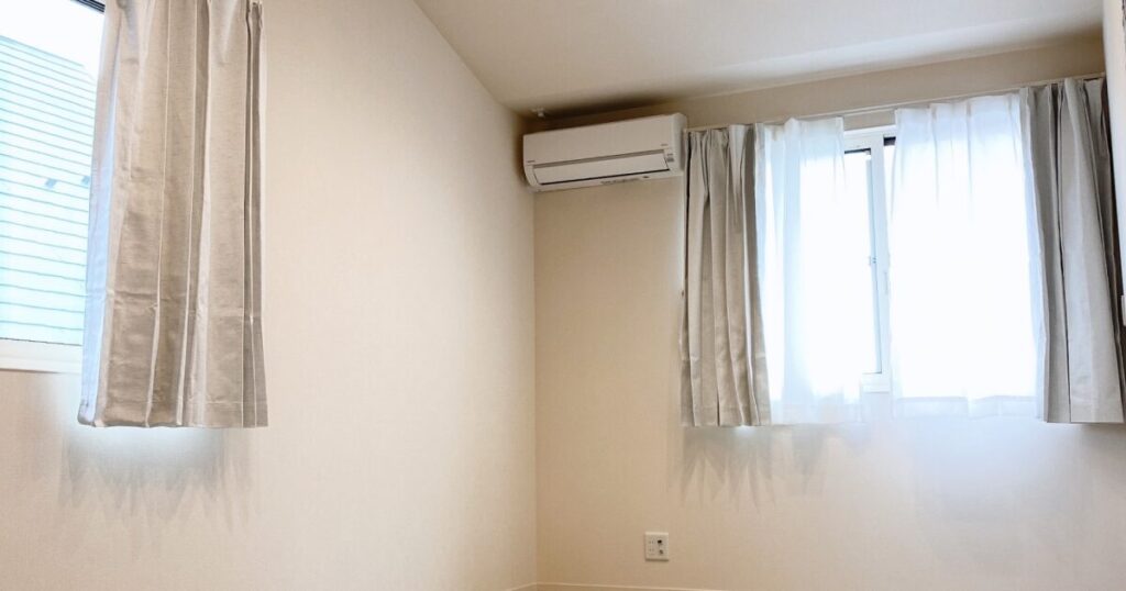 窓とカーテンのあるシンプルな空き部屋