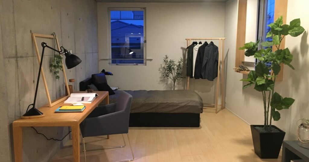 観葉植物とデスクがあるシンプルな寝室