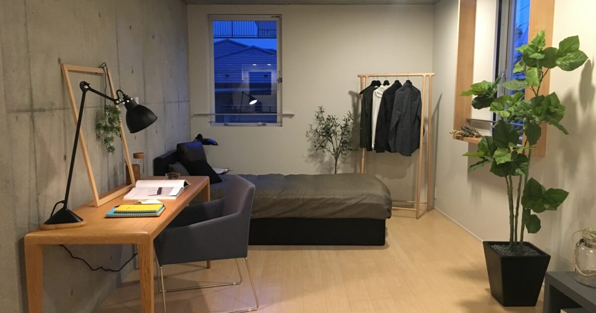 観葉植物とデスクがあるシンプルな寝室